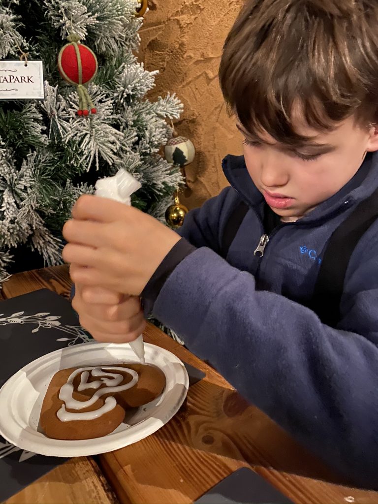 child decorating gingerbread heart