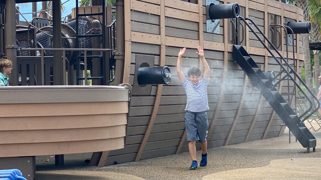 boy enjoying mist cannons at adventure playground